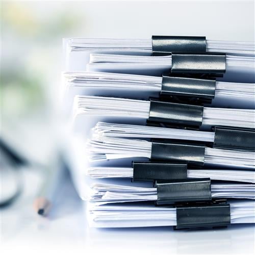 A stack of documents and resources on a desk.