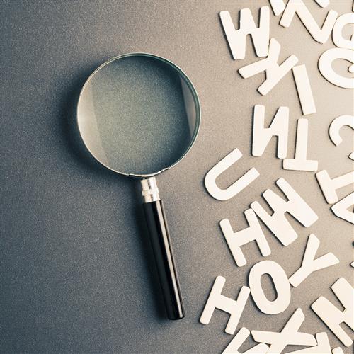 A magnifying glass next to letters representing a glossary