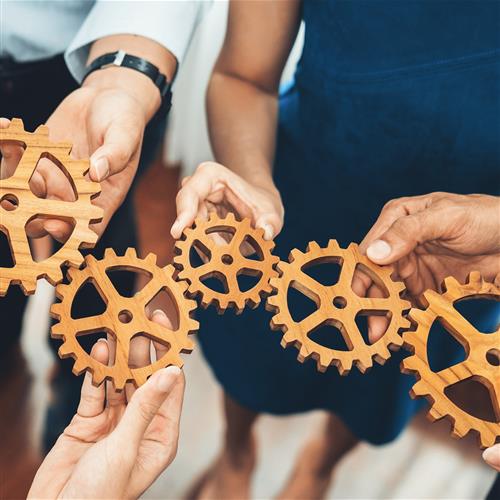 People holding interlocking gears representing the procurement process.