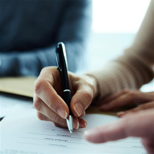 A woman's hand signing a framework agreement